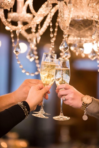 Friends cheers glasses of champagne to welcome in the new year in Bryan, TX
