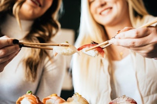 Two girls holding sushi from Kanji Sushi at Lake Walk in Bryan, TX