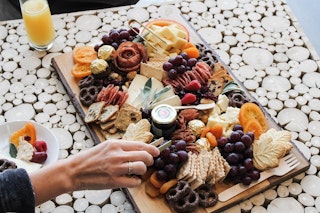 Person eating a charcuterie board at The Board Room at Lake Walk in Bryan, TX