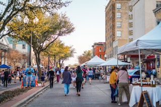 A crowd of people and vendors at a First Friday event in downtown Bryan, TX.